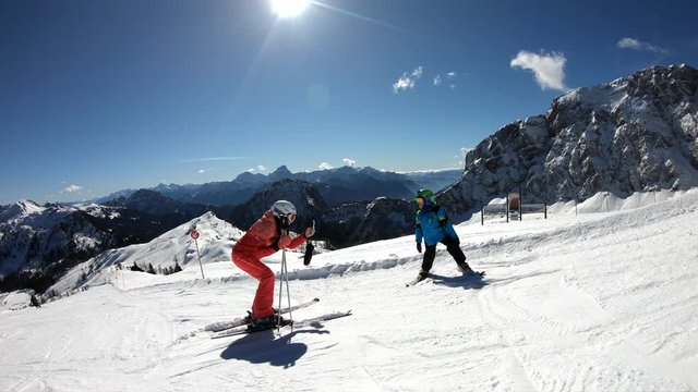 Active holiday winter alps. Mother taking pictures on cell phone of little boy in Austrian Alps. Boy poses while skiing.