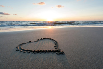 heart in the sand at sunset