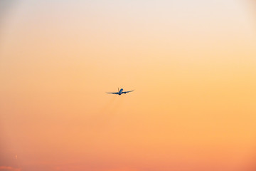 夕焼け空へ飛び立つ旅客機