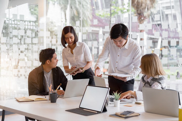 Diverse asian young startup business group working together and sharing idea at modern office.