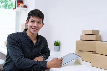 Confident small business owner sitting and taking customer orders by white screen tablet mockup at home office.