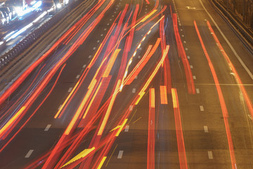 The lights of blurred motion of cars on the highway. Long exposure of big urban night traffic in the city. In the summer urban highway filled cars. Rush hours. To be late. 