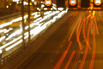 The lights of blurred motion of cars on the highway. Long exposure of big urban night traffic in...