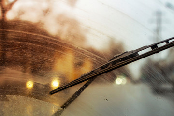 Windshield wipers from inside of car, season rain, front and background blurred with bokeh effect - obrazy, fototapety, plakaty