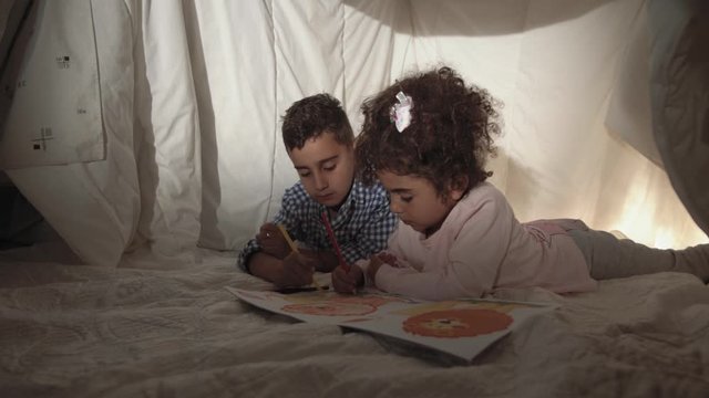 Cute little mixed race children preschoolers play and paint coloring