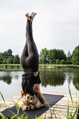 Kobieta uprawiająca jogę i medytację na świeżym powietrzu. Asana nad jeziorem. Instruktor...