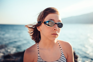 Fototapeta na wymiar Portrait of girl wearing swimming goggles on the beach