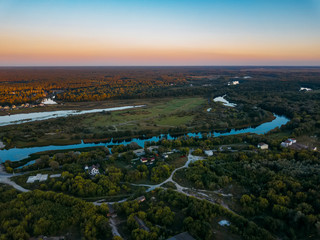 Summer rural landscape, aerial view. Village, forest and river from drone flight