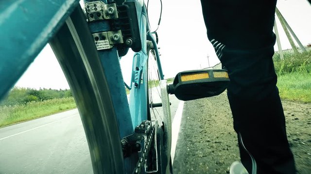 Man walks with his bike along rural road, close-up shot