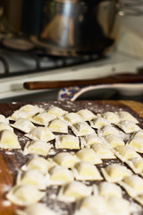 Stuffed pasta on a wooden board, prepared for cooking.