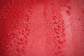 Closeup red car paint surface with hydrophobic ceramic coating