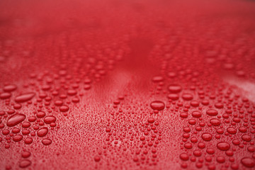 Closeup red car paint surface with hydrophobic ceramic coating