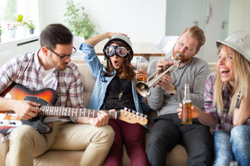 Friends having fun and partying in house and playing music