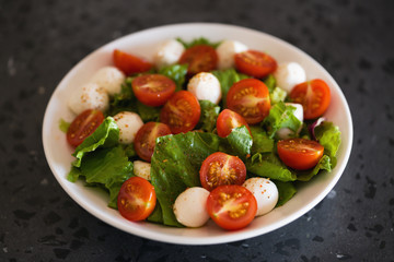 Fototapeta na wymiar Salad with mozzarella balls tomatoes and mix salad