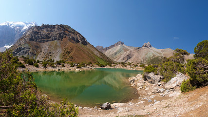 Scenery Fann mountains in Tajikistan. Wild mountain nature with lake on clear day. Beautiful Kulikalon lake in Fan mountains. Hiking