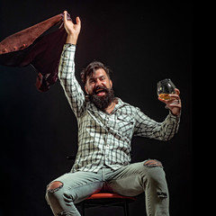 Alcohol abuse: drunk man looking at a glass of whiskey. Actual social problem. Treatment for...
