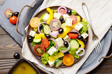 Top view at Mediterranean diet dish greek salad on vintage metal tray
