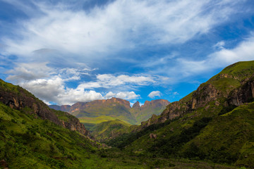 Green valley with clouds against the blue sky