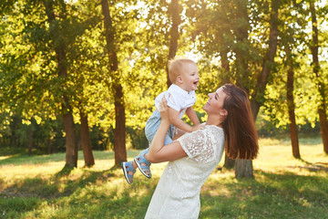 Obraz premium Autumn family walk in forest. Happy mother and baby boy. Family with little son in autumn park. Family and mother's day. Children Protection Day. Family picnic