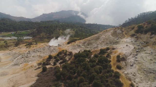 plateau with volcanic activity, mud volcano Kawah Sikidang, geothermal activity and geysers. aerial view volcanic landscape Dieng Plateau, Indonesia. Famous tourist destination of Sikidang Crater it