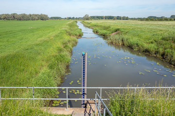 Ditch with water level gauge in The Netherlands.
