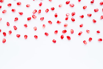 Pomegranate seeds on white. Copy space