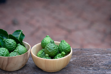 Fresh organic bergamot fruits on wooden table with blur green garden background