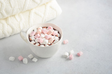 Cup of hot chocolate with marshmallows on a gray concrete background. 