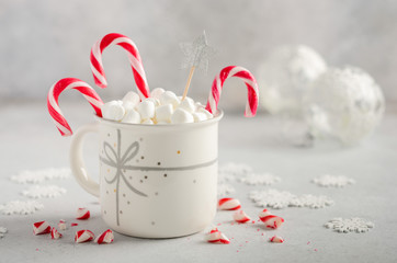 New Year or Christmas concept. Composition with marshmallows and candy canes on a gray concrete background. 