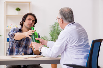 Young male alcoholic visiting old doctor