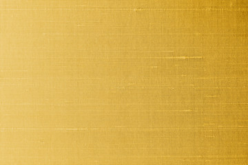 Gold silk fabric background of satin texture cotton cloth pattern with shiny gradient silky woven...