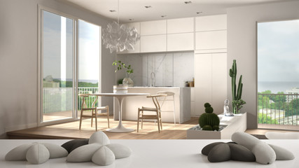 White table, desk or shelf with five soft white pillows in the shape of stars or flowers, over blurred modern living room, kitchen, white architecture interior design