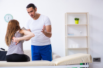 Obraz premium Young woman visiting male doctor physiotherapist