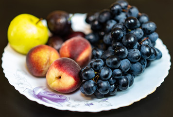Fruit on a plate grapes peach plum apple