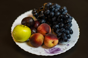 Fruit on a plate grapes peach plum apple