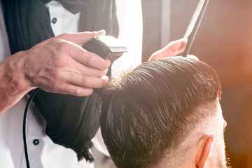 Barbershop. Professional makes hairstyle a man with a beard .