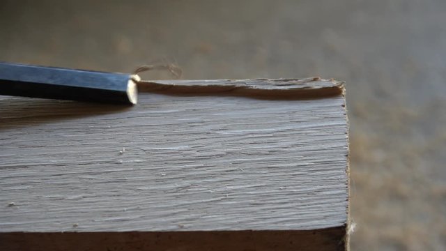 mit einem Stechbeitel wird Holz bearbeitet