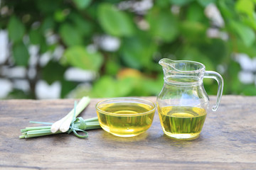 Lemongrass essential oil in glass bottles on natural green background