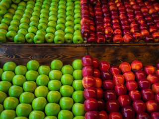 Apples green and red lie on a wooden showcase