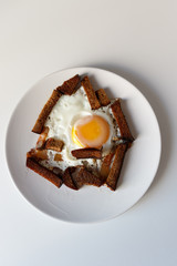fried egg, bread and lard on a white plate, on a white background