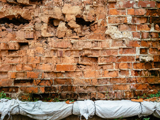 An old, crumbling brick wall and a heating main passing by