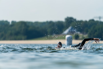 Athletes in wetsuits swimming in a lake
