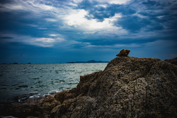 Rocks and clouds in the sky at sea