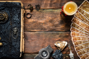 Tarot cards and a book of magic on the table.