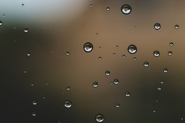 Raindrops on window glass close up. water drops abstract macro background