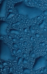 Drops of blue liquid on plastic surface