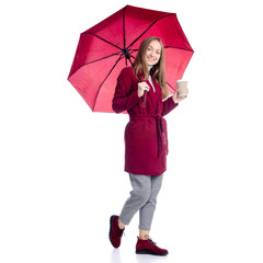 Woman in red coat standing with umbrella and cardboard cup of coffee looking autumn cold rain on white background isolation