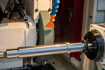 The cylindrical grinding machine make the surface finishing on the metal shaft control by CNC...