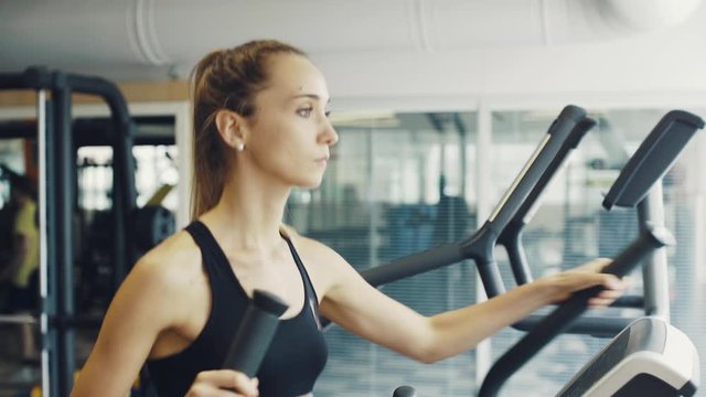 Fit woman exercising on a stair stepper at the gym