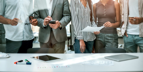 Office life. Cropped photo of business people standing together in the modern office